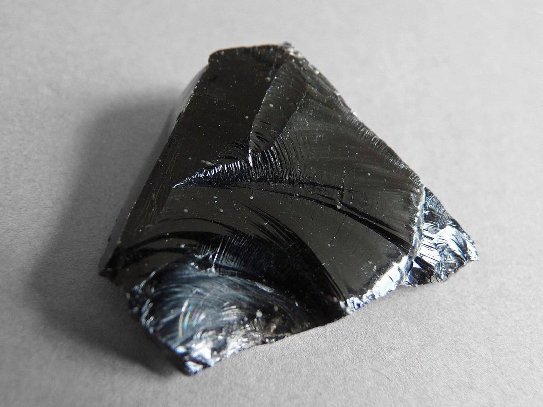 A polished black obsidian stone for spiritual protection and grounding, presented by Lydazz.