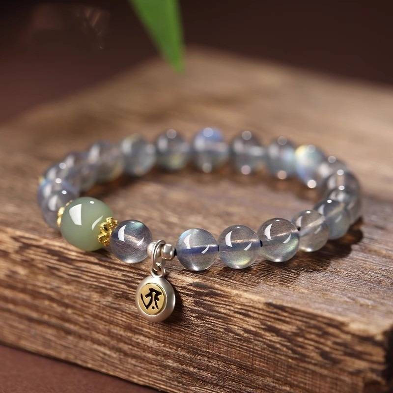 Calm Guardian Chinese Zodiac Buddha Charm Bracelet - Front view prop styling shot of white crystal and jade bracelet