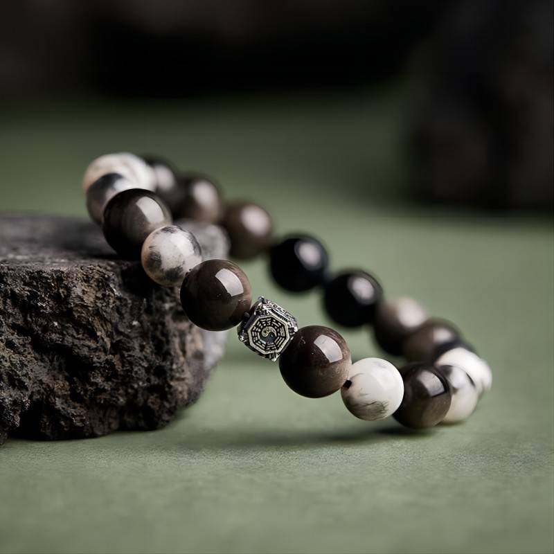 Feng Shui Yin Yang Bagua Charm Bracelet - side view prop-styled shot with black obsidian and blue tiger eye beads