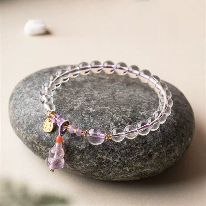 Fortune Gourd Amulet Bracelet - Clarity &amp; Balance - Prop styling shot of white crystal bracelet