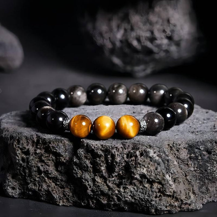 Grounded Confidence And Attract Wealth Bead Bracelet - Prop styling shot of obsidian and tiger eye bracelet