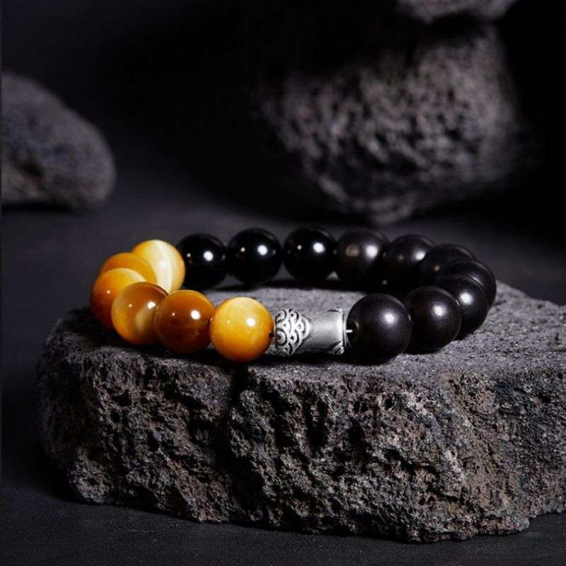 Grounded Confidence And Attract Wealth Bead Bracelet  - Prop styling shot of black obsidian and tiger eye bracelet