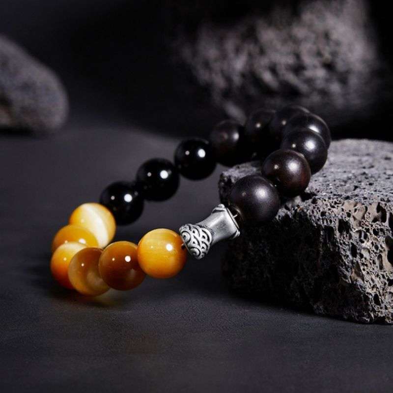 Grounded Confidence And Attract Wealth Bead Bracelet  - Side view staged shot of black obsidian and tiger eye bracelet