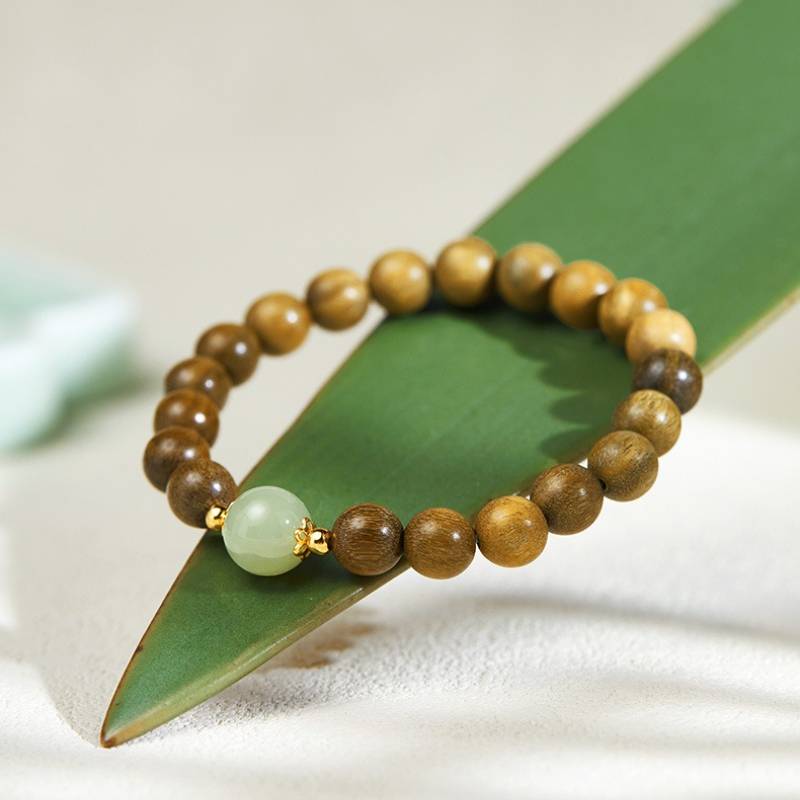 Grounded Harmony Sandalwood Bracelet With Hetian Jade Focal Bead - Clarity & Luck - front view prop-styled shot