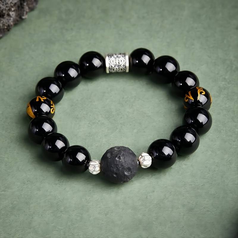 Grounded Mantra Bracelet - Protection & Focus - Staged shot of black obsidian bracelet with obsidian meteorite bead