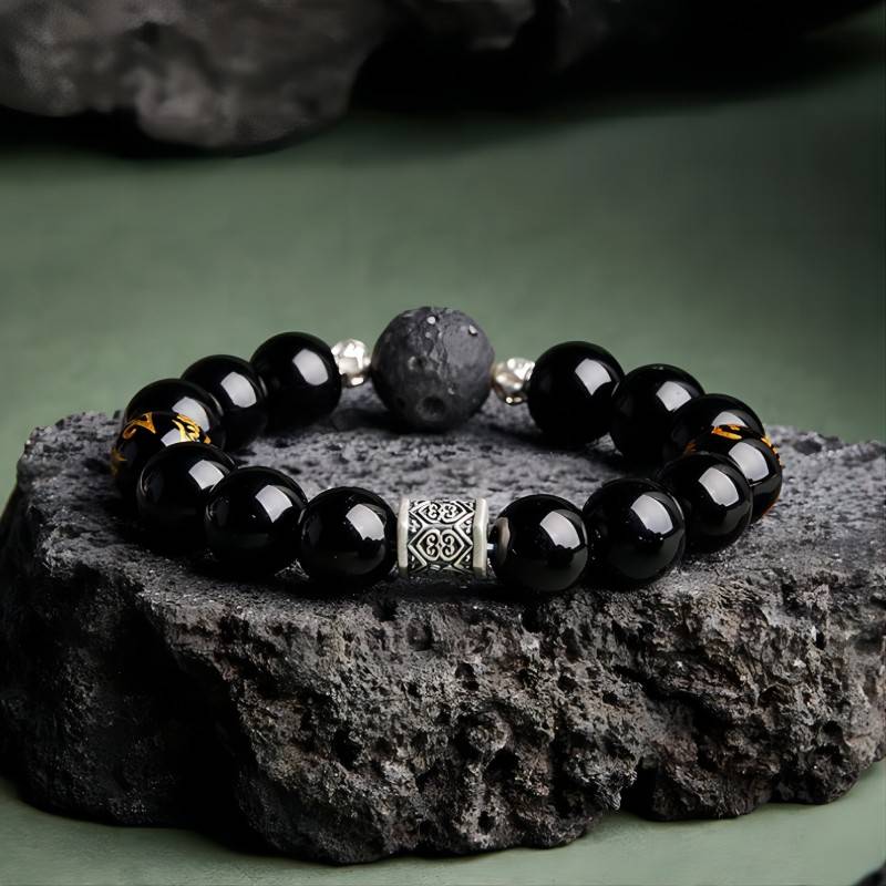 Grounded Mantra Bracelet - Protection & Focus - Prop styling shot of black obsidian bracelet with obsidian meteorite bead