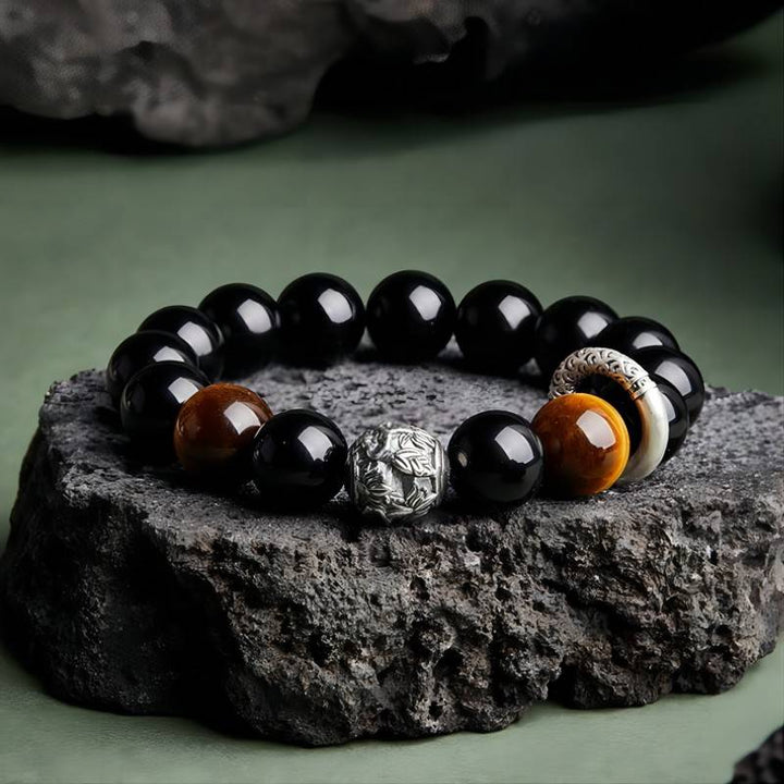 Grounded Protection &amp; Fortune Obsidian Bracelet - Front view prop styling shot of black obsidian and tiger eye bracelet
