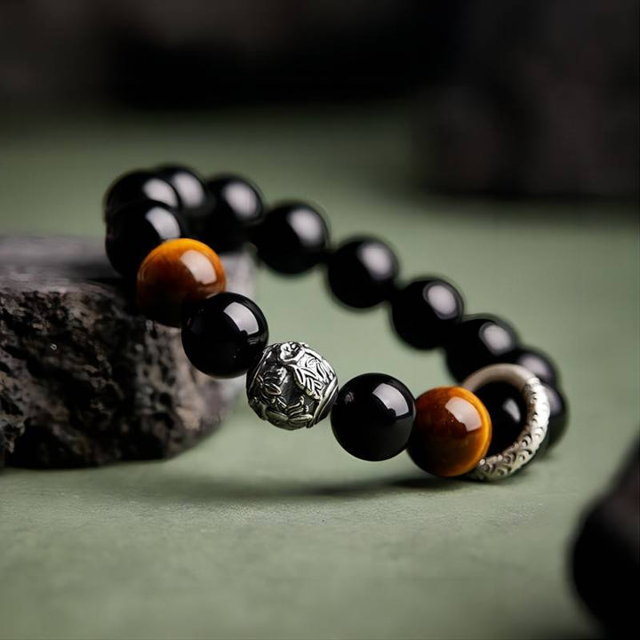 Grounded Protection &amp; Fortune Obsidian Bracelet - Side view prop styling shot of black obsidian and tiger eye bracelet