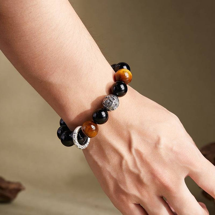 Grounded Protection &amp; Fortune Obsidian Bracelet - On wrist wearing display of black obsidian and tiger eye bracelet