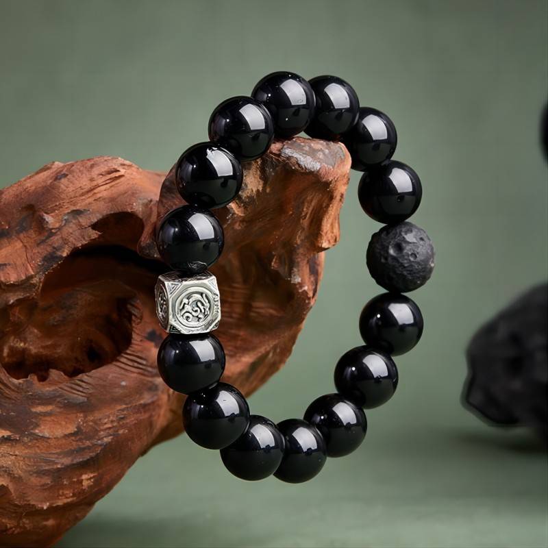 Grounded Protection Obsidian Bracelet - Side view prop styling shot with silver focal bead