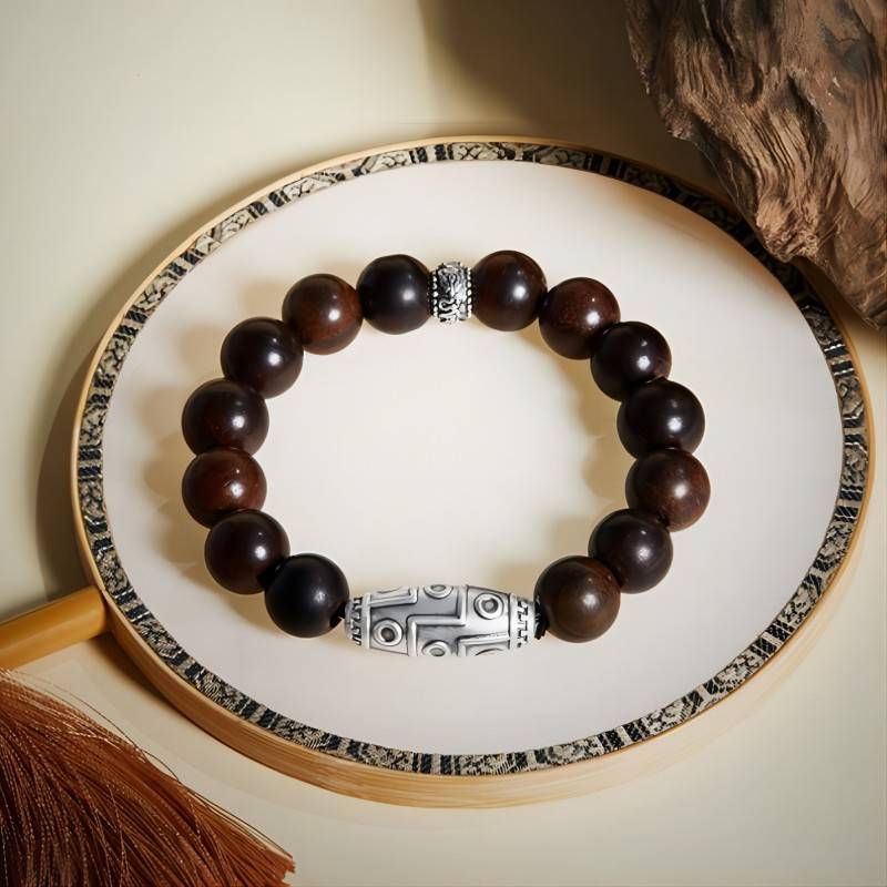 Grounded Wisdom Silver Nine - Eye Dzi Bead Bracelet - Luck & Insight - Prop styling shot of rosewood bracelet