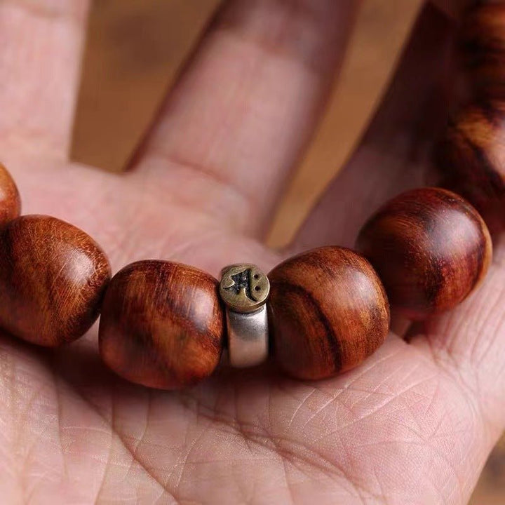 Guardian Sanskrit Zodiac Charm Natural Rosewood Bracelet - Peace &amp; Smooth Fortune - close-up on-hand shot