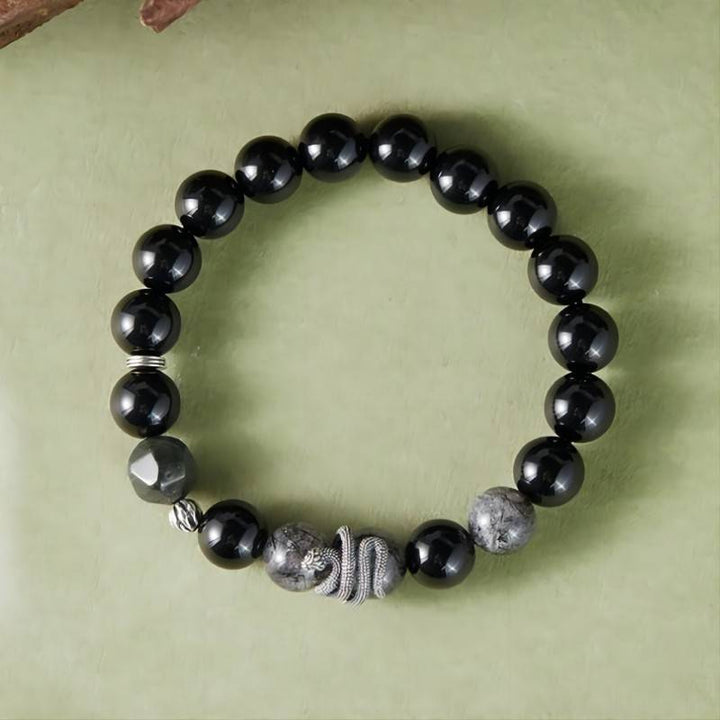 Mamba Serpent Charm Bracelet - Vitality &amp; Grounding - Top view staged  shot of black obsidian bracelet