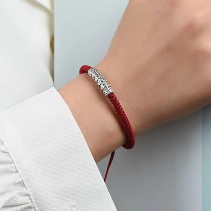Protection Knot Braided Cord Bracelet - On wrist wearing display shot of red style with sterling silver charm