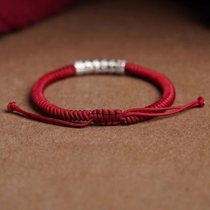 Protection Knot Braided Cord Bracelet - Staged shot of red style with sterling silver charm
