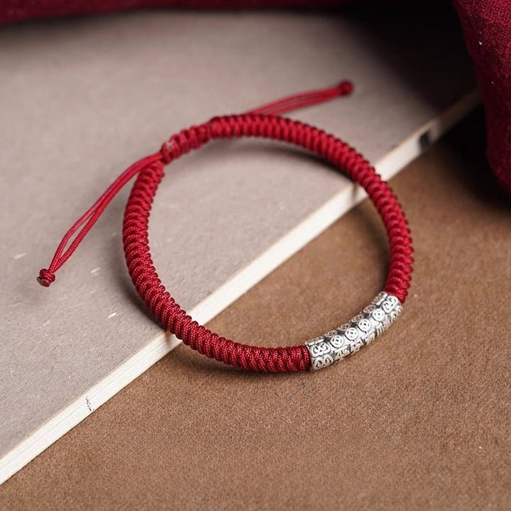 Protection Knot Braided Cord Bracele - Prop styling shot of red style with sterling silver charm