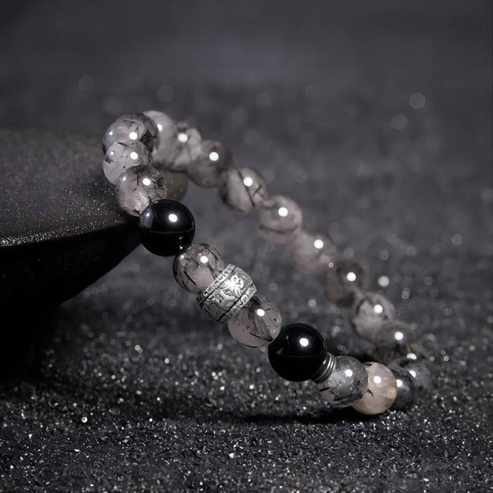 Protection Mantra Bracelet - Abundance &amp; Clarity - Side view staged shot of black obsidian and sliver bracelet