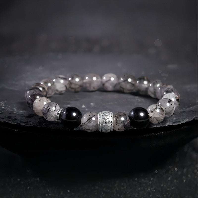 Protection Mantra Bracelet - Abundance & Clarity - Prop styling shot of black obsidian and sliver bracelet