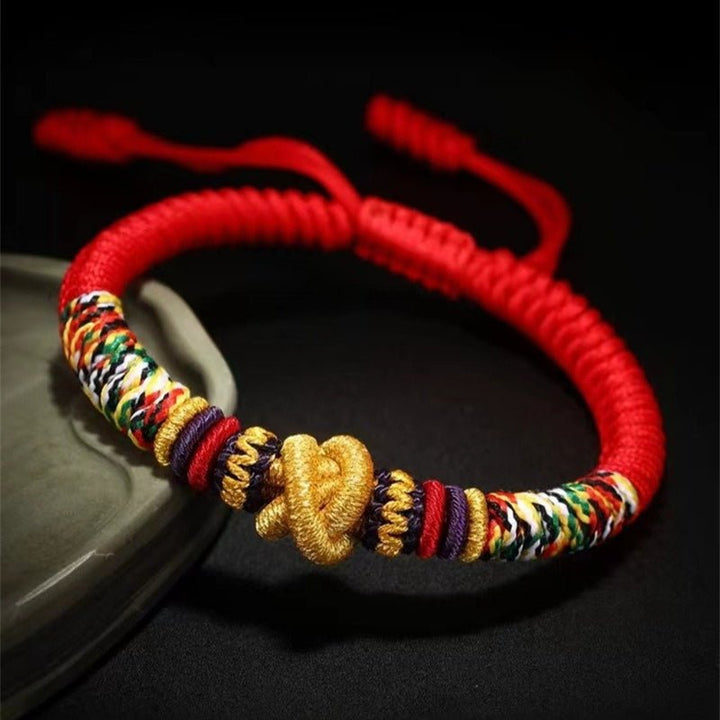 Protection Mantra Charm Bracelet - Peace &amp; Auspicious Blessing - Staged shot of red braided cord bracelet