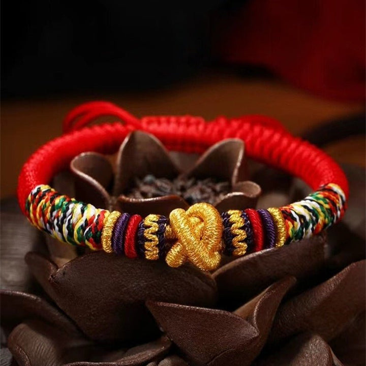 Protection Mantra Charm Bracelet - Peace &amp; Auspicious Blessing - Prop styling shot of red braided cord bracelet