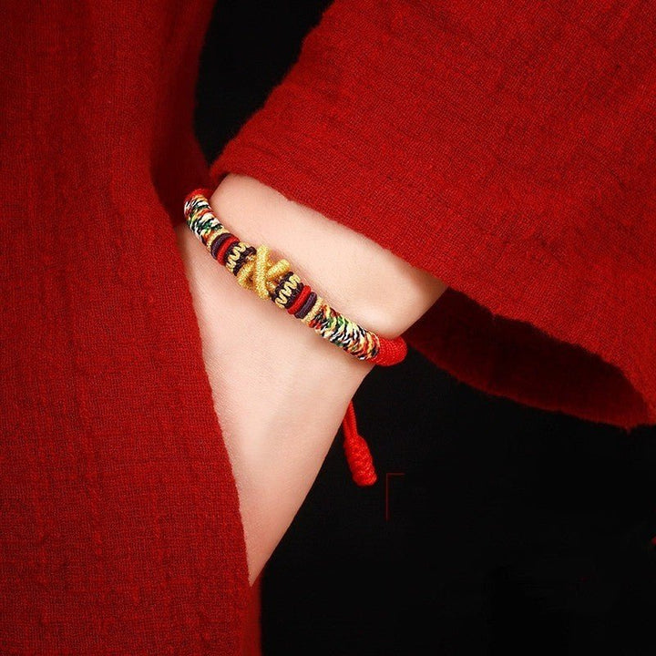 Protection Mantra Charm Bracelet - Peace &amp; Auspicious Blessing - On wrist wearing display of red braided cord bracelet