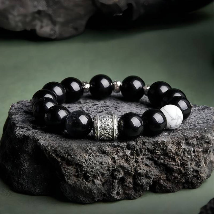 Six Syllable Mantra Bracelet - Protection • Clarity • Grounding - Prop styling shot of black obsidian bracelet