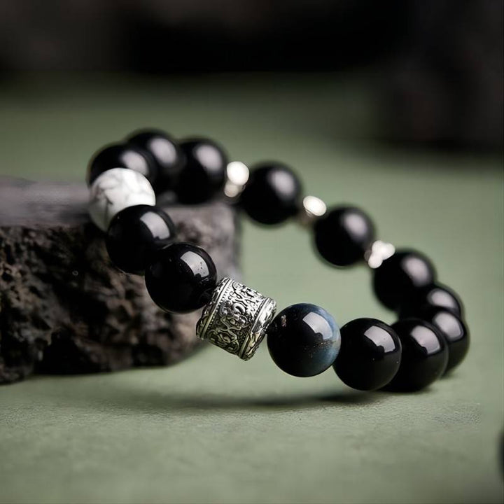 Six Syllable Mantra Bracelet - Protection • Clarity • Grounding - Side view staged shot of black obsidian bracelet