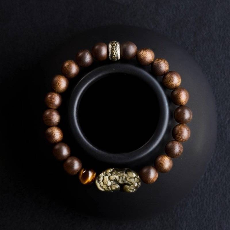 Wealth Guardian Pi Yao & Mantra Bracelet - Fortune & Auspicious Energy - top view prop-styled shot with agarwood beads