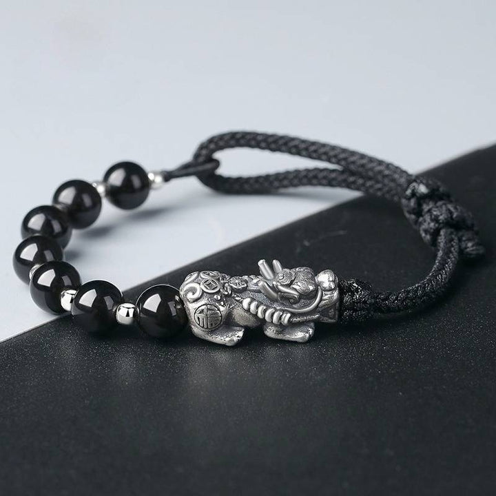 Wealth Guardian Pixiu Charm Bracelet - Protection &amp; Grounding - Staged shot of black obsidian and sliver braid bracelet 1